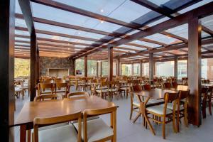una sala da pranzo con tavoli e sedie in legno di Laghetto Golden a Gramado