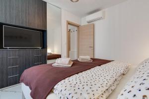 a bedroom with a bed and a flat screen tv at Summer Dream Apartment in Sveti Filip i Jakov +43 photos