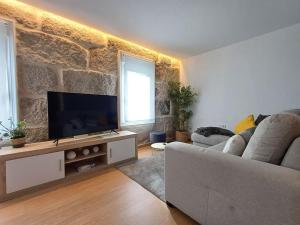 a living room with a couch and a flat screen tv at Descansa y disfruta de Ourense en Villa Fayma in Ourense