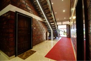 a hallway with a red carpet and a brick wall at Forest County Resort in Mahabaleshwar