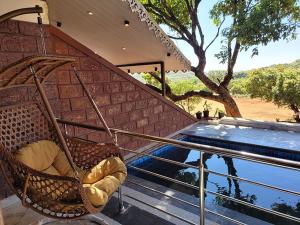 a chair sitting on a porch next to a swimming pool at Forest County Resort in Mahabaleshwar