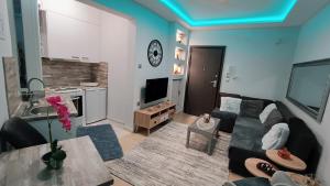 a living room with a couch and a table and a kitchen at Cute apartment in Veria