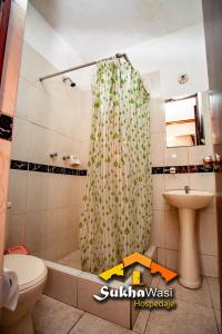 a bathroom with a shower curtain and a toilet and a sink at SukhaWasi in Arequipa