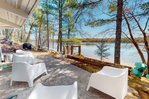 un grupo de sillas blancas en un patio con vistas al lago en The Octagon on Big Bass, en Eagle River