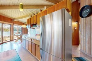 una nevera de acero inoxidable en una cocina con armarios de madera en The Octagon on Big Bass, en Eagle River