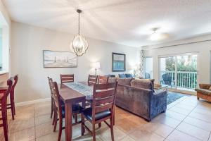 a dining room and living room with a table and a couch at TOPS'L Summit 210 in Destin