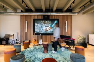 una persona parada en una habitación con una pantalla de proyección en Stadsklooster Dordt Hotel&Hostel, en Dordrecht