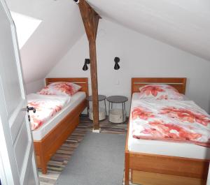 2 Betten in einem Zimmer mit Dachgeschoss in der Unterkunft VINTAGE HOUSE Ferienwohnung LANDHAUS LAAVE 