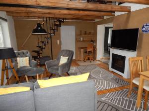 uma sala de estar com um sofá e cadeiras e uma televisão em VINTAGE HOUSE Ferienwohnung LANDHAUS LAAVE 