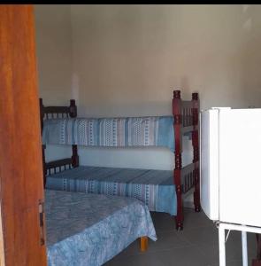 3 literas en una habitación con nevera en Pousada Canto Feliz, en Peruíbe
