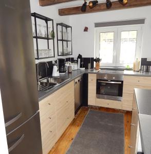 uma cozinha com armários de madeira e electrodomésticos de aço inoxidável em VINTAGE HOUSE Ferienwohnung LANDHAUS LAAVE 