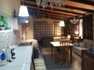 a kitchen and living room with a table and a couch at Casa della Quercia in San Giovanni la Punta