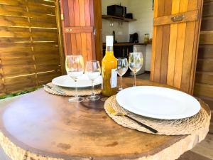a table with glasses and a bottle of wine at Bungalow le Balisier in Pointe-Noire