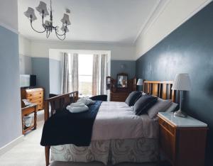 a bedroom with a large bed with a blue wall at Wavecrest in Barmouth