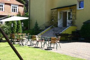 une terrasse avec des chaises, des tables, une table et une maison dans l'établissement Willa Roma, à Świnoujście