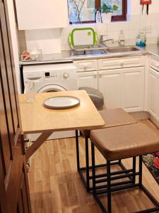 a small kitchen with a table and a sink at Spacious flat with free parking in Croydon in Croydon