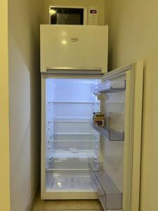 un réfrigérateur vide avec une porte ouverte dans une pièce dans l'établissement Apartmán s manželskou posteľou, à Bratislava