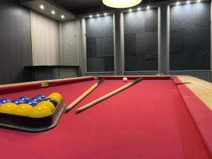 a red pool table with cue balls and bats at PartyPad Newcastle in Saint Peters