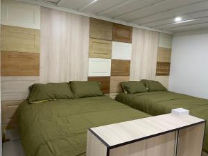 ein Schlafzimmer mit 2 Betten und einem Tisch darin in der Unterkunft PartyPad Newcastle in Saint Peters