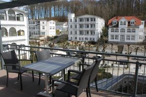 a table and chairs on a balcony with buildings at FEWO - Riverboat 02-55 in Ostseebad Sellin