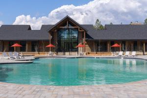 a large swimming pool with chairs and a building at Firefall Ranch Yosemite in Groveland