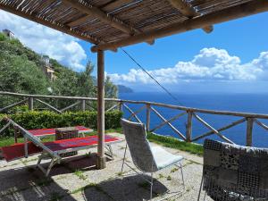 un patio con mesa, sillas y el océano en villa lucia, en Conca dei Marini