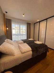 a bedroom with a large bed with a large window at Apartaments Airport Komputerowa Premium in Warsaw