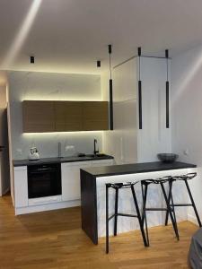 a kitchen with a black counter top in a room at Apartaments Airport Komputerowa Premium in Warsaw