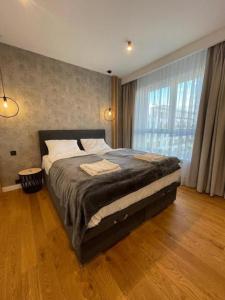 a bedroom with a large bed and a large window at Apartaments Airport Komputerowa Premium in Warsaw