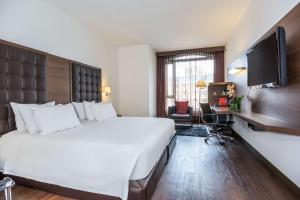 um quarto de hotel com uma cama grande e uma televisão de ecrã plano em NH Collection Bogota Andino Royal em Bogotá