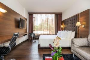 um quarto de hotel com uma cama e um sofá em NH Collection Bogota Andino Royal em Bogotá