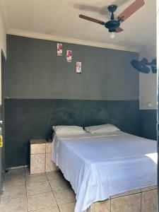 a bedroom with a bed with a blue wall at Pousada Sol in Goiânia