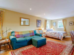 uma sala de estar com um sofá azul e uma cama em 1 Bed in Bonar Bridge 89058 em Culrain