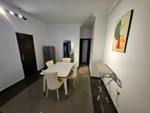 a dining room with a white table and chairs at Elkora Luxury Apartments in Ikeja