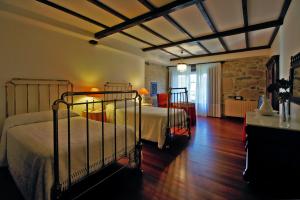 a bedroom with two beds and a stone wall at Casa Grande De Trives in Puebla de Trives