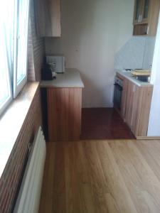 una pequeña cocina con armarios de madera y suelo de madera. en Apartment Icovi, en Varna
