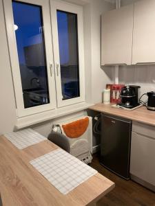a kitchen with a table and a counter top at Harmony Apartament in Suwałki