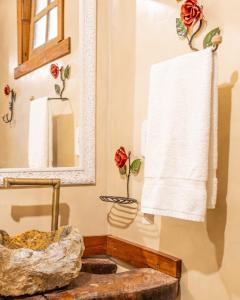 bagno con lavandino, specchio e asciugamano di Pousada Das Araras a Itaúnas
