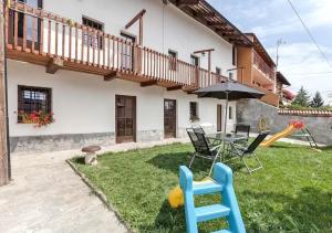 un patio trasero con mesa, sillas y sombrilla en Bed and Breakfast Giaveno en Giaveno