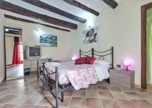 1 dormitorio con 1 cama con almohadas rojas y TV en Bed and Breakfast Giaveno, en Giaveno