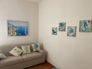 a living room with a couch and pictures on the wall at About Capri in Anacapri
