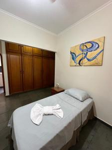 Un dormitorio con una cama con una toalla. en Dulc en Ribeirão Preto