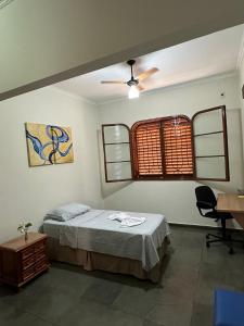 um quarto com uma cama e uma ventoinha de tecto em Dulc em Ribeirão Preto