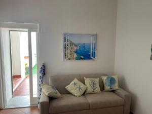 a couch in a living room with a picture on the wall at About Capri in Anacapri