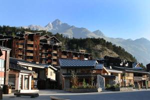 a group of buildings with mountains in the background at Résidence Les Portes De La Vanoise - 2 Pièces pour 4 Personnes 193151 in Villarodin-Bourget