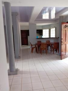 een woonkamer met een tafel, stoelen en zuilen bij Casa de vacaciones el volcán in Managua