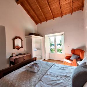 サン・テオトーニオにあるMonte dos Papa Figosのベッドルーム1室(ベッド1台、椅子、鏡付)