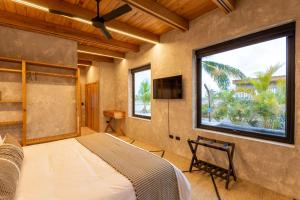 a bedroom with a bed and a large window at Seabird Dwellings Villa with Private Splash Pool and Dock in Placencia Village