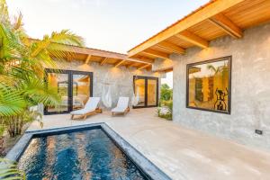 a villa with a swimming pool and a house at Seabird Dwellings Villa with Private Splash Pool and Dock in Placencia Village