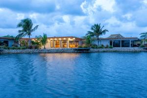 a house on the shore of a body of water at Seabird Dwellings Villa with Private Splash Pool and Dock in Placencia Village